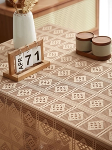 Detailed close-up of hollowed-out lace tablecloth with diamond pattern and texture