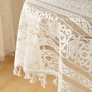 Detailed macro view of beige hollow lace tablecloth with boho fringes and knit pattern