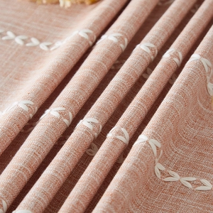 Brown tassel tablecloth with white embroidered leaves on cotton linen fabric texture