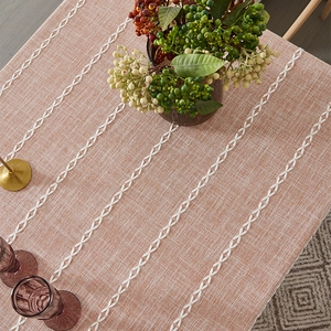 Detail of rust red linen tablecloth featuring white criss-cross woven textured pattern