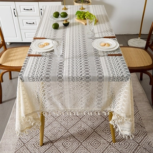 Bohemian lace tablecloth with geometric hollow patterns and chic beige tassels on wood table