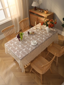 Close-up of bohemian lace tablecloth featuring bird and branch embroidery with tassel edges