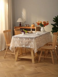 Detailed embroidery of birds and branches on bohemian lace tablecloth with tassels