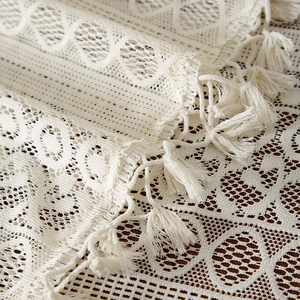 Detail of bohemian lace tablecloth showing intricate crochet patterns and fringe edges