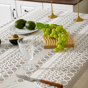 Detail of bohemian lace tablecloth with circular cutout patterns and elegant tassels