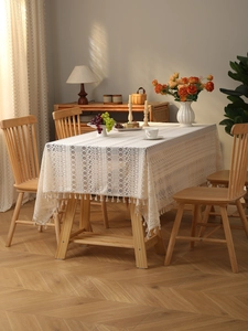 Detail of bohemian lace tablecloth featuring geometric hollow embroidery and fringe tassels