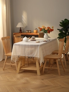 Detailed shot of beige lace tablecloth with hollow geometric patterns and fringe edges