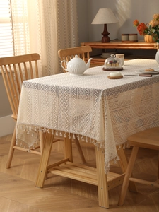 Close-up of bohemian lace tablecloth with geometric hollow patterns and fringe tassels