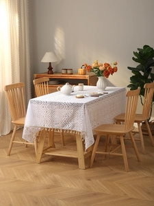 Detail of white bohemian lace tablecloth with hollow patterns and fringe tassels