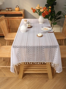 Detail view of bohemian lace tablecloth featuring hollow geometric patterns and tassel edges