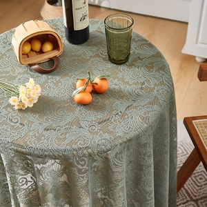 Detailed view of sage green lace round tablecloth with elegant ruffled French cottage design