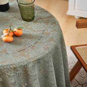 Detail of mint green lace tablecloth with vintage floral patterns and ruffled edges