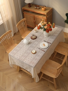Detailed view of bohemian ivory lace tablecloth with floral hollow patterns and fringe