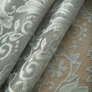 Macro view of light blue lace fabric with vintage floral mesh pattern and ruffled edges