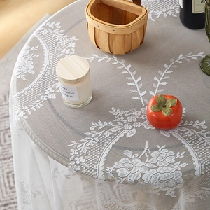 Close-up of white floral lace tablecloth with ruffle edge and intricate embroidery