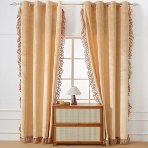 Detailed view of light orange velvet curtains with elegant hollow lace trim and grommets