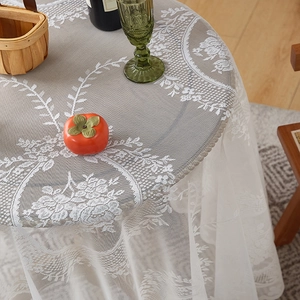 Close-up of French lace tablecloth featuring vintage floral embroidery and scalloped edges