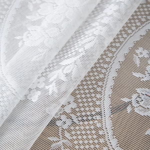 White French lace tablecloth with rose patterns and ruffle edges on a wooden table