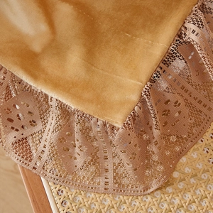 Detailed view of golden velvet curtain with elegant hollowed-out lace embroidery edge