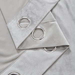 Detailed macro view of light grey chenille blackout curtain with silver metal grommets
