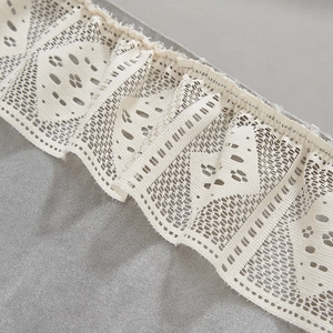 Macro detail of grey chenille fabric featuring elegant white ruffled lace border trim