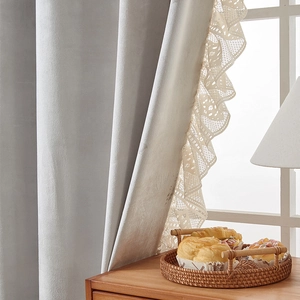 Detail of grey velvet curtain showing delicate white lace ruffle edge and texture