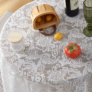 Close-up of white lace tablecloth featuring vintage floral embroidery and scalloped edges
