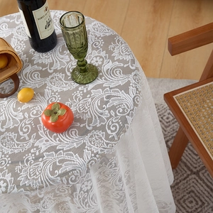 Close-up of French lace tablecloth with vintage floral patterns and ruffled edges on table