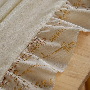 Detailed macro view of beige linen fabric with intricate vintage lace trim embroidery