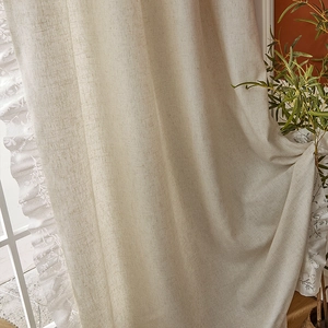 Detail of vintage linen curtain with white lace edging and delicate floral embroidery