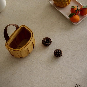 Detail of hand-woven wooden storage basket featuring premium brown leather handle and texture