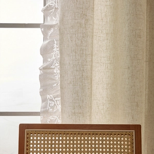 Detail of vintage linen curtain with delicate white floral lace embroidery and ruffled edges