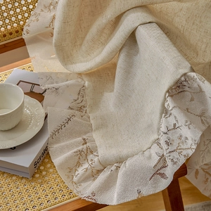 Close-up of vintage linen curtain with exquisite lace embroidery and ruffled edges
