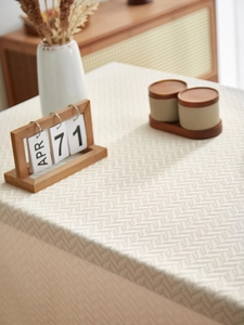 Detail of vintage beige herringbone tablecloth with waterproof fabric and textured weave