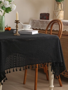 Detailed close-up of vintage black lace tablecloth featuring intricate hollow floral patterns