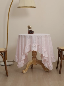 Detail of pink hollow-out lace tablecloth with vintage floral patterns and ruffled edges
