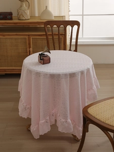 Close-up of pink round lace tablecloth with vintage floral pattern and ruffled edges