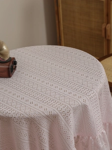 Close-up of pink lace tablecloth featuring heart-shaped crochet patterns and ruffled edges