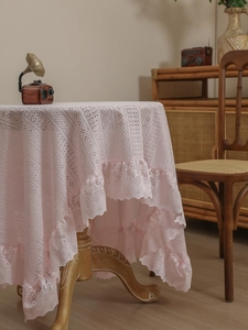 Detail of pink lace tablecloth featuring retro floral hollow knit and ruffled wavy edges