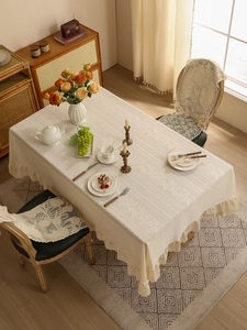 Detail of vintage cream lace tablecloth with elegant ruffled edges and floral patterns