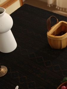 Detailed macro view of dark brown woven tablecloth with textured diamond lace patterns