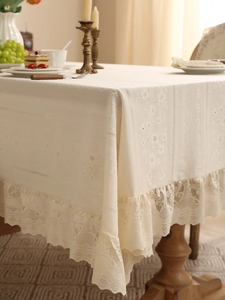 Close-up of vintage lace tablecloth with intricate floral embroidery and ruffle edges