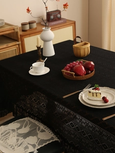 Detailed close-up of black retro lace tablecloth with elegant crochet hollow patterns