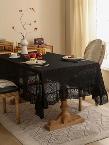 Detailed view of black lace tablecloth with vintage hollow patterns and elegant ruffled edges