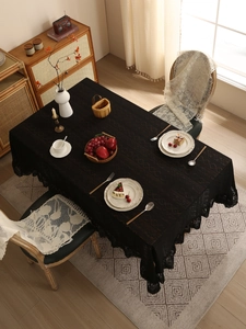 Close-up of black lace tablecloth with brown diamond embroidery and elegant vintage borders