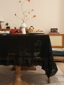 Detailed view of black lace tablecloth with intricate floral patterns and ruffled edges