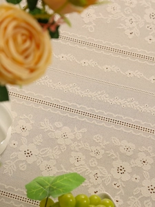 Detailed macro view of beige lace tablecloth with floral patterns and scalloped edges