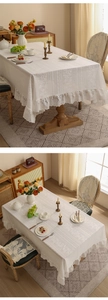 Detail of white lace tablecloth with vintage floral embroidery and ruffled edge design