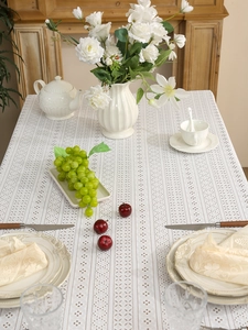 Detail of cream lace tablecloth featuring intricate hollow diamond mesh pattern on table
