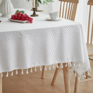 White rectangular tablecloth with herringbone weave texture and decorative fringe tassels
